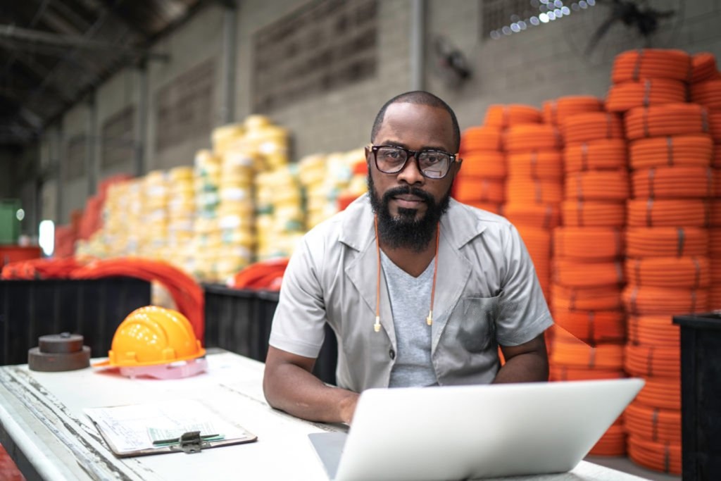 Ingénieur camerounais devant une usine au coucher du soleil